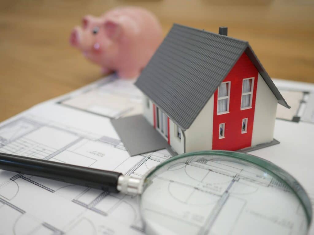 Model house and magnifying glass representing a date-of-death home valuation