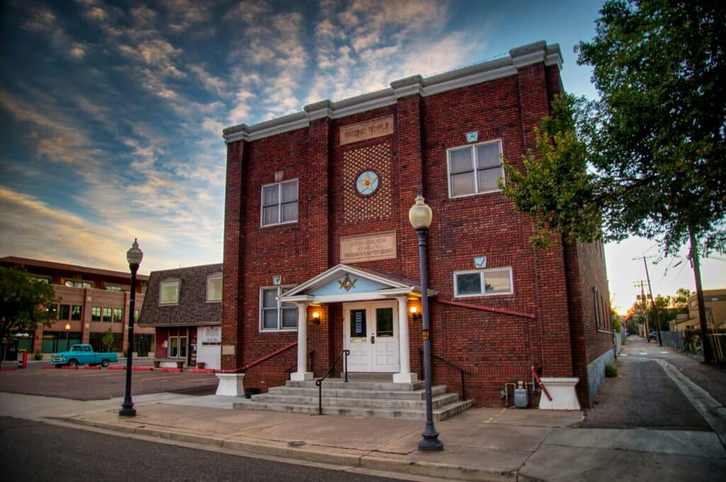 Historic red brick building with a clock in a Colorado downtown like Littleton