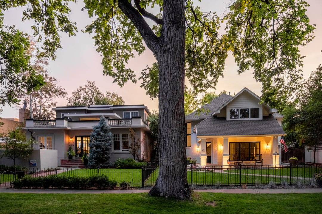 Craftsman bungalow and classic Denver home on a tree-lined street at dusk